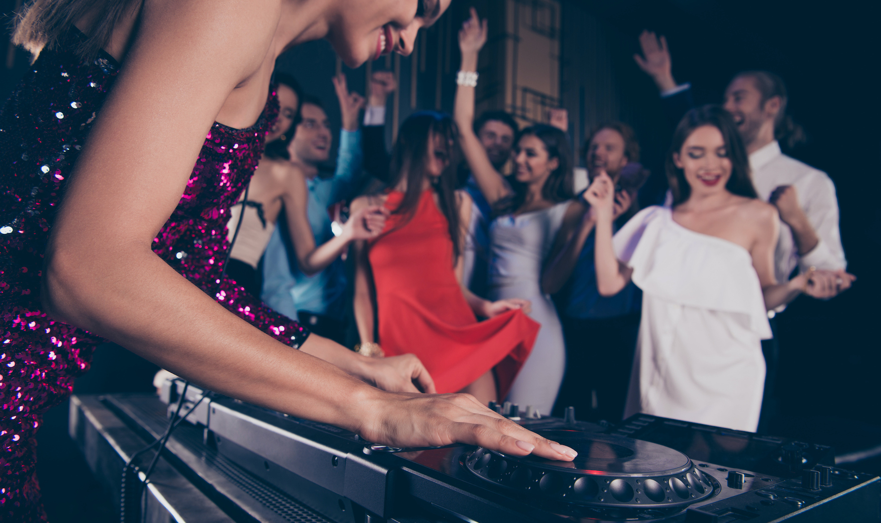 Cropped photo of lady dj play sound on corporate, feast, festive using djs mixing console control against blured background with fancy crowd (Cropped photo of lady dj play sound on corporate, feast, festive using djs mixing console control against blu